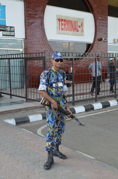 Ein Flughafenpolizist posiert mit seiner Waffe für ein Foto