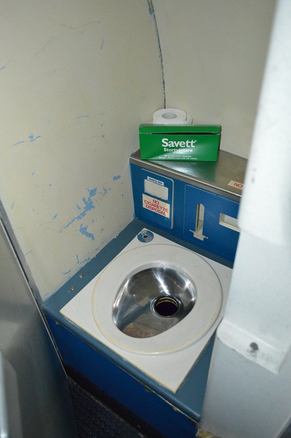 Im Bild nach links schließt die geöffnete Türe des WCs den Raum zur Passagierkabine. Gut erkennen kann man die Biegung des Rumpfes an der Hinterseite.
