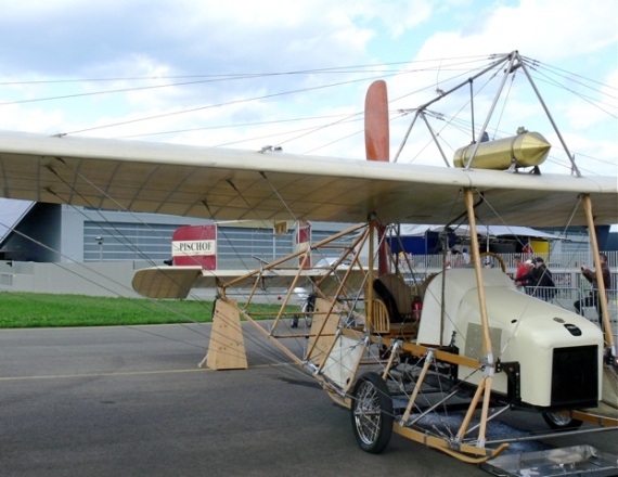 1909 von Ing. Alfred Ritter von Pischof entwickelt, startete dieser Eindecker am 9. März 1910 zu seinem Jungfernflug auf dem Flugplatz Wiener Neustadt. Damit der Ingenieur sein Flugzeug selbst steuern durfte, legte er im April 1910 seine Pilotenprüfung beim AERO-Club ab – als zweiter Österreicher überhaupt. Charakteristisch ist besonders die spezielle Propeller-Konstruktion, die sich hinter der Tragfläche befindet. Wegen ihrer Schnauze wird die Autoplan oft als „Limousine der Lüfte“ bezeichnet – und wartete mit damals unvorstellbaren Neuerungen auf. Etwa dem auskoppelbaren Propeller, der, wie bei Oldtimern, den Start des Motors per Kurbel ermöglichte. Zudem konnte der Motor im Stand warmlaufen, was bedeutete, dass man keine starken Männer mehr brauchte, die das gestartete Flugzeug bis zum Abflug festhielten. Wegweisend war auch die Dicke der Tragflächen, die modernen Exemplaren in Robustheit nichts nachstehen und die Korbsessel, in denen Pilot und Passagier nebeneinander so etwas wie Komfort fanden.  Die auf der AIRPOWER11 gezeigte Pischof Autoplan ist eine originalgetreue Nachbildung und wurde ab 2001 in über 8000 Arbeitsstunden von Initiator Walter Krobath und dem Team rund um Anton Ott gebaut. Karl Habsburg-Lothringen taufte diesen einzigartigen Eindecker mit der speziellen Propeller-Konstruktion hinter den Tragflächen im Jahr 2005 in Wiener Neustadt – an jenem Ort, wo Alfred Ritter von Pischof 95 Jahre zuvor den Erstflug wagte - Foto: Franz Zussner