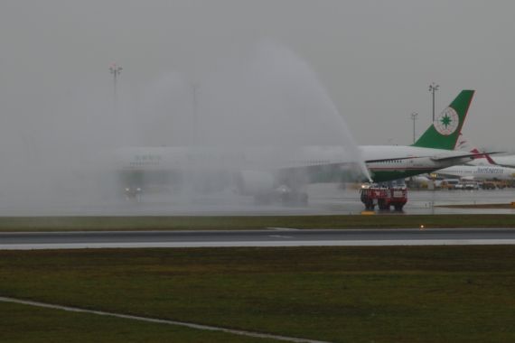 Neben der Fluhafenfeuerwehr beteiligte sich auch der Wettergott am Water Salute für die EVA AIR Triple Seven ... - Foto:: Kevin Schrenk Neben der Fluhafenfeuerwehr beteiligte sich auch der Wettergott am Water Salute für die EVA AIR Triple Seven ... - Foto:: Kevin Schrenk