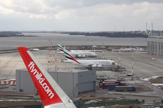 Kurz nach dem Start in Hamburg-Finkenwerder; im Hintergrund sind zwei A380 in den Farben von Emirates zu sehen