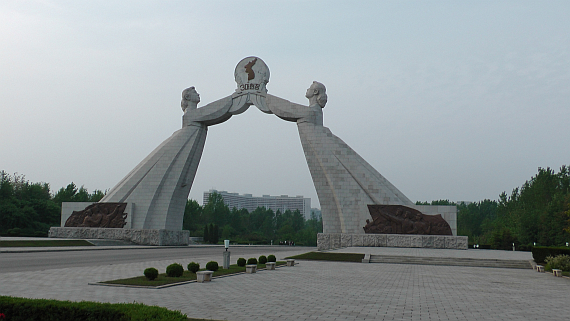 Pyongyang zur Rush Hour. Die Statue zeigt die beiden Teile des Landes, und soll den Wunsch nach Wiedervereinigung ausdrücken.