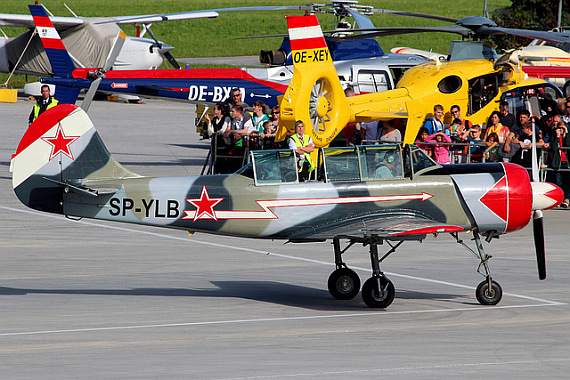 Private Yak-52, im Hintergrund zwei Hubschrauber der Flugrettung bzw. der Flugpolizei