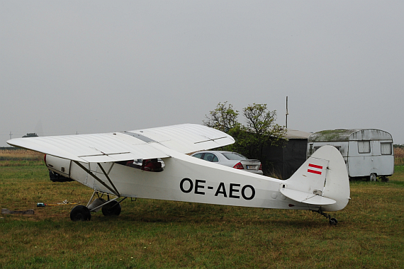 Die OE-AEO auf dem Feldflugplatz zwischen Podersdorf und Illmitz; im Hintergrund sind der Wohnwagen und eine Lagerbaracke zu erkennen.