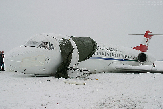 Einsatzkräfte deckten kurz nach dem Abtransport der Insassen die offene Türe ab und versuchten mit einer Plane auch, den Schriftzug "Austrian Airlines" unkenntlich zu machen - Foto: Andreas Zeitler - Flying Wings Einsatzkräfte deckten kurz nach dem Abtransport der Insassen die offene Türe ab und versuchten mit einer Plane auch, den Schriftzug "Austrian Airlines" unkenntlich zu machen - Foto: Andreas Zeitler - Flying Wings