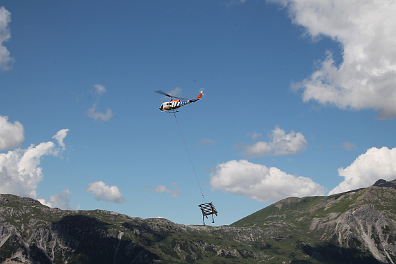 Der Hubschrauber fliegt Lawinenverbauungen in den Steilhang... - Foto: Der Hubschrauber fliegt Lawinenverbauungen in den Steilhang... - Foto: