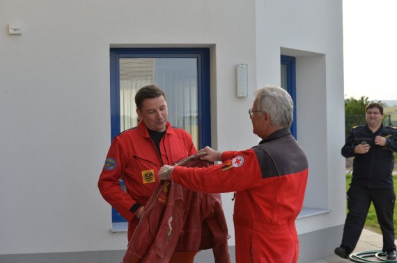 Brunner überreicht jene Lederjacke, die zu seinem Markenzeichen wurde, an Cpt. Grassinger.