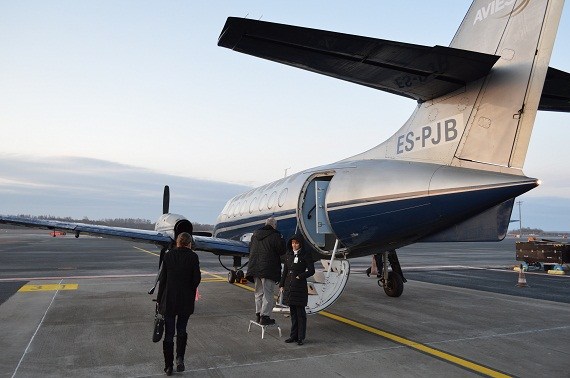 Die Flugbegleiterin empfängt ihre Passagiere.