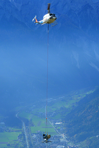 Ungewöhnlicher Anblick: Die Bell 205 von Wucher Helicopter fliegt Hochleistungs-Schneekanonen zum Hangar nach Zürs. - Foto: Fritz Salcher/Wucher Helicopter