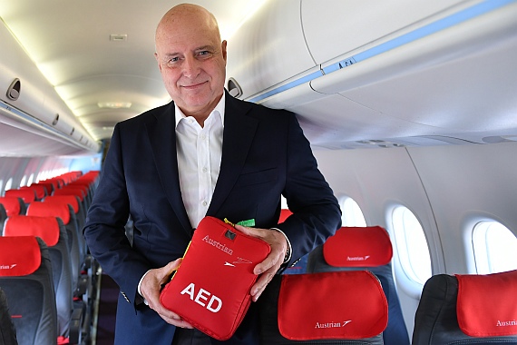 AUA-CEO Kay Kratky präsentiert eines der Geräte an Bord einer Q400: "Ich bedanke mich bei dem verantwortlichen Projektteam, dass die Ausstattung der Maschinen mit Defis in Rekordzeit gelungen ist."