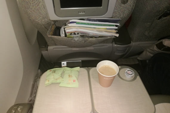 Das von EVA Air als "Elite Class" bezeichnete Premium-Economy-Produkt bietet Reisenden ein gewisses Komfortplus durch bequemere Sitze und nicht zuletzt mehr Abstand zum Vordermann - hier gut erkennbar bei ausgeklapptem Tischchen und zurückgeklappter Lehn